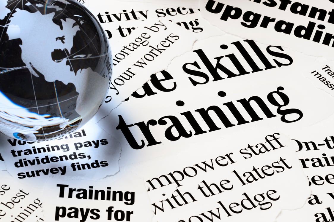 Headlines on staff empowerment through training under globe paperweight